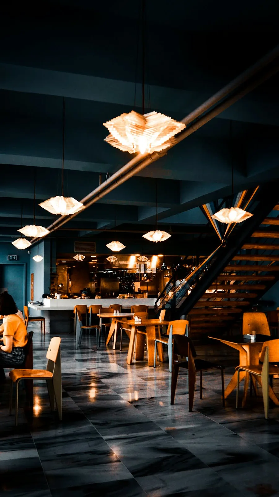 Un restaurante de noche, con lámparas encendidas sobre el salón